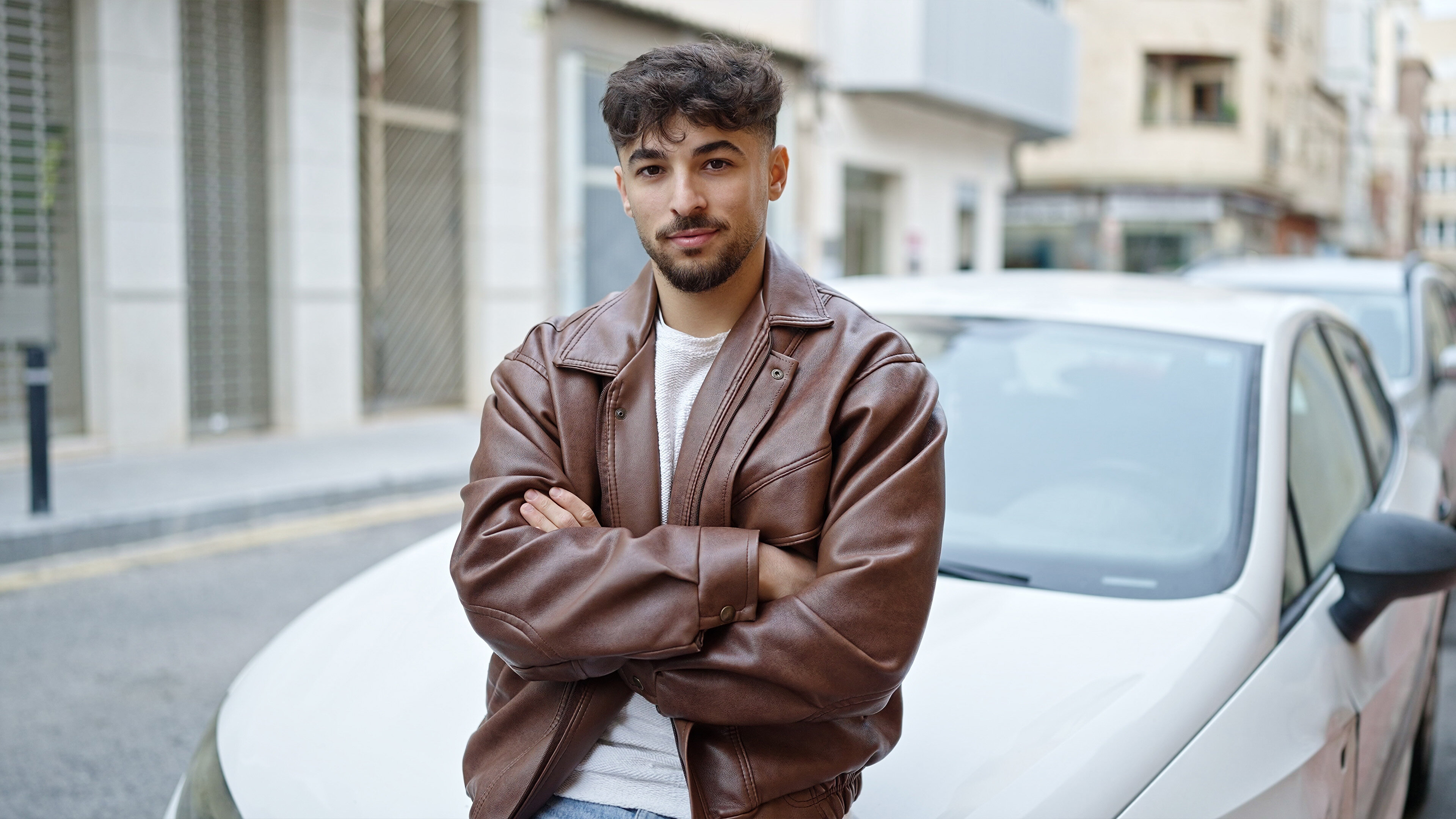Jeune homme devant une voiture